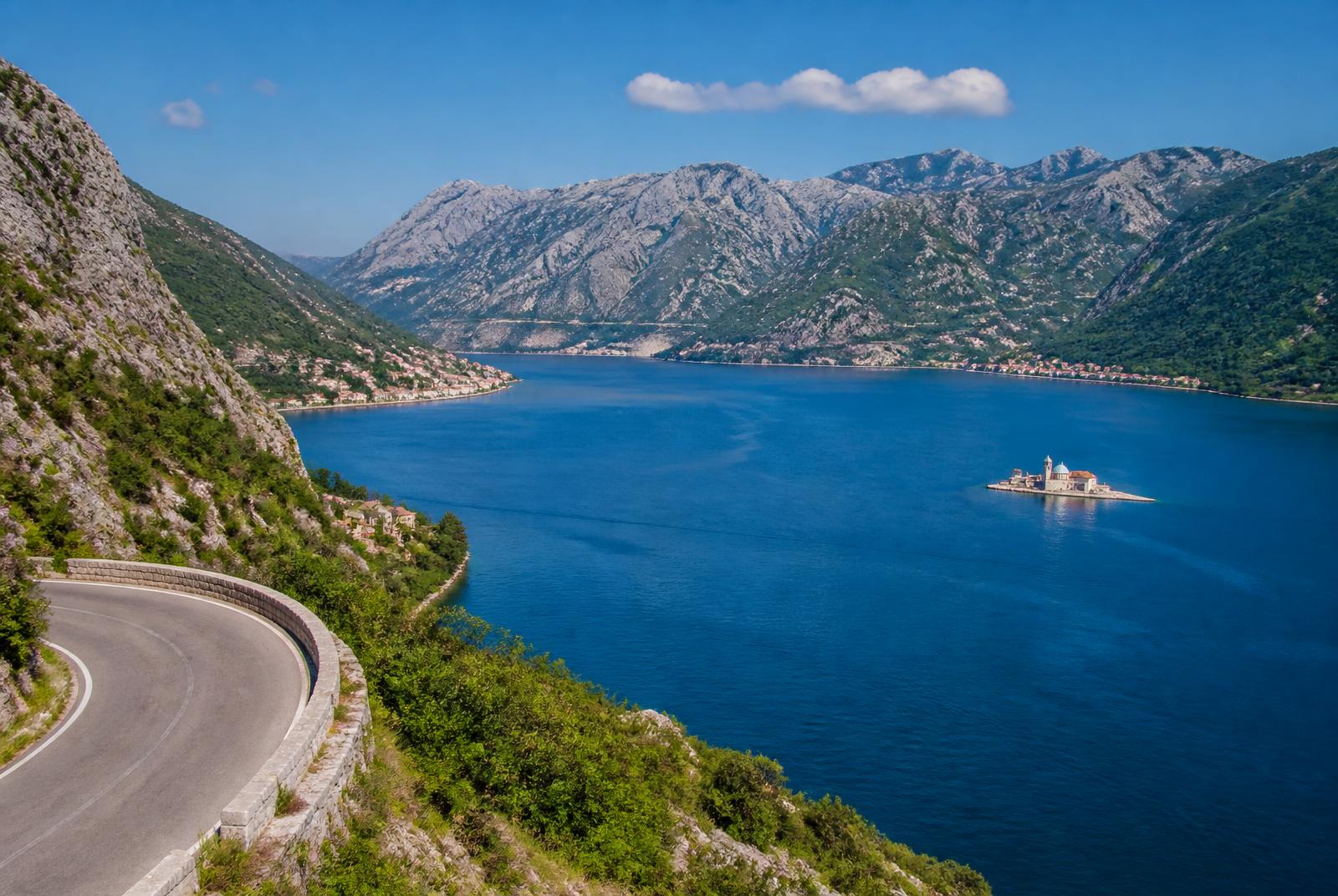 The Bay of Kotor in Montenegro seen from a coastal road, with the island church of Our Lady of the Rocks