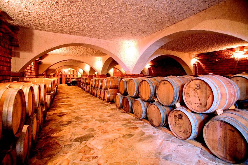 Oak wine barrels stacked in a vaulted stone cellar on the Pelješac peninsula